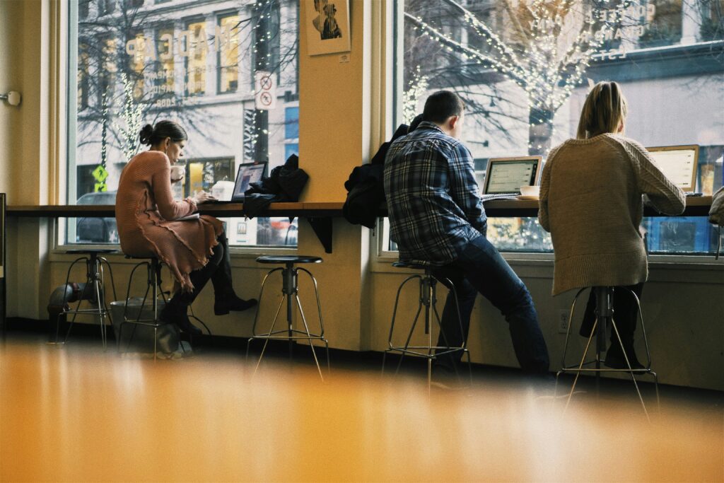 Decorative image of college students working on their theses in a coffee shop