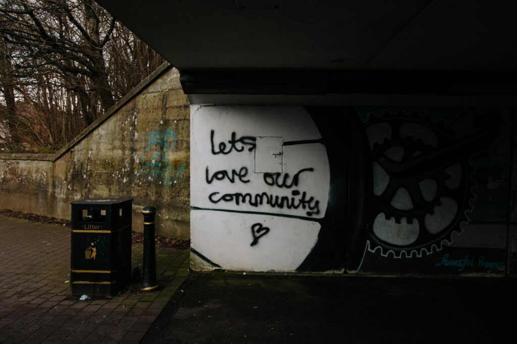 Decorative image of graffiti on a wall stating "let's love our communities", for Educopia's "Making Community Spaces Safer" blog series